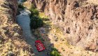 Birds eye view of a camping set up along the Bruneau River with red rafts in the water 