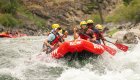 Group of travelers paddling through whitewater rapids on a guided rafting trip down the Middle Fork of the Salmon River in Idaho.