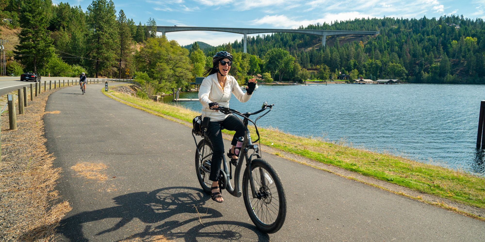 A women smiling and laughing while pedaling her E-bike in Northern Idaho