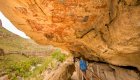 People walking underneath old cave paintings in Santa Teresa Canyon, Baja California