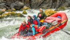 raft in between two rocks going through a rapid on the Snake River through Hells Canyon in Idaho