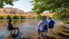 people sitting on chairs in river