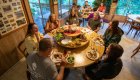 People gathered around a table at Marial Lodge while rafting the Rogue River