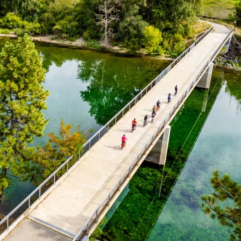 Birds eye view of people biking along a bridge 