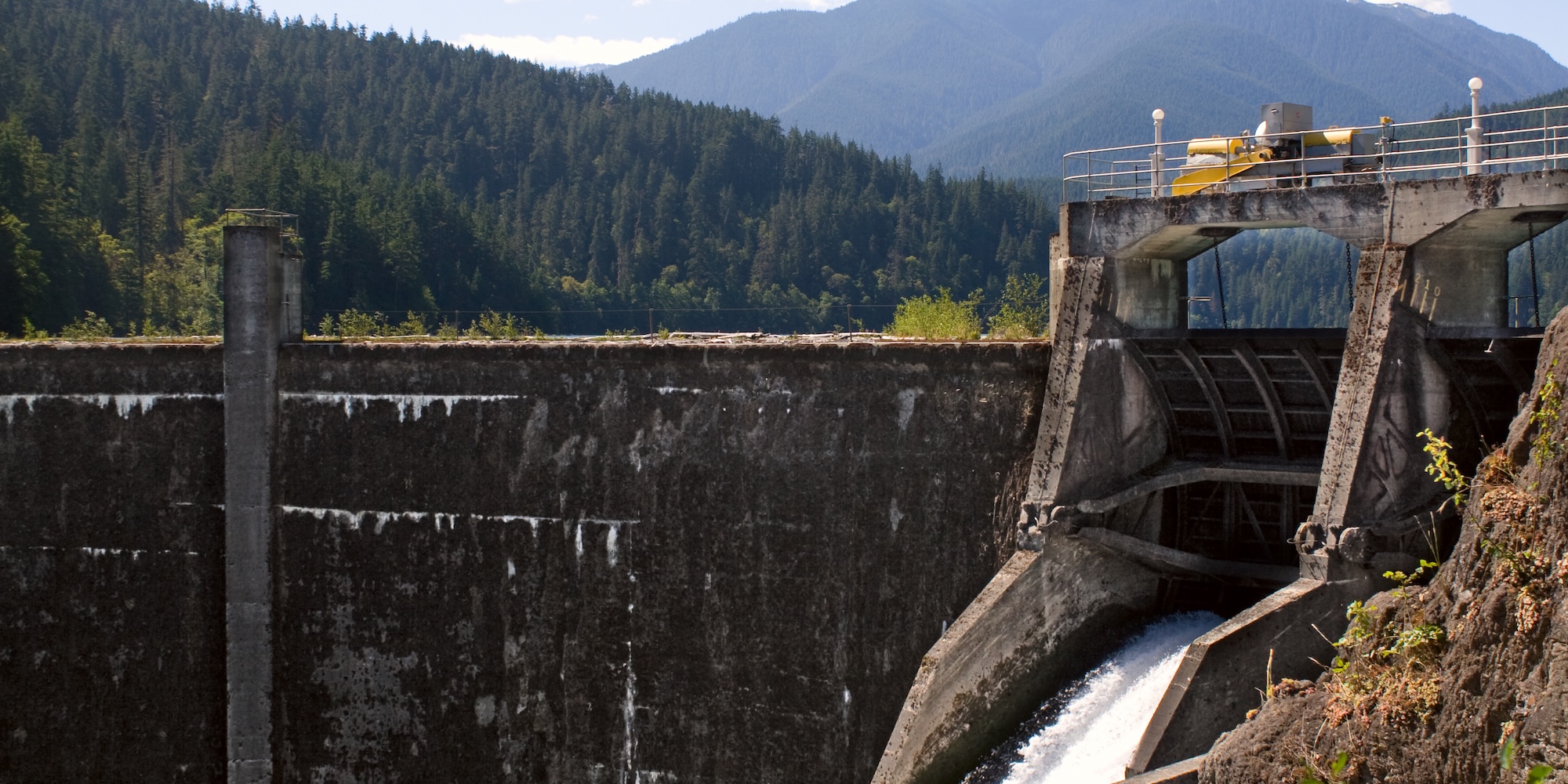The Elwha river dam before removal with Washington state mountains covered in evergreens in the background.