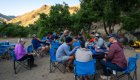 People sitting around a table eating dinner on a multi-day Snake River rafting trip