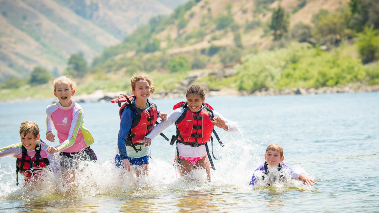4 girls running through the water on the salmon river
