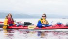 A mom and daughter in a tandem sea kayak in British Columbia