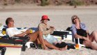 Travelers relaxing and laughing on a sandy beach in Loreto after a day of kayaking in Baja Mexico, enjoying the perfect mix of adventure and leisure on a Mexico kayak tour.