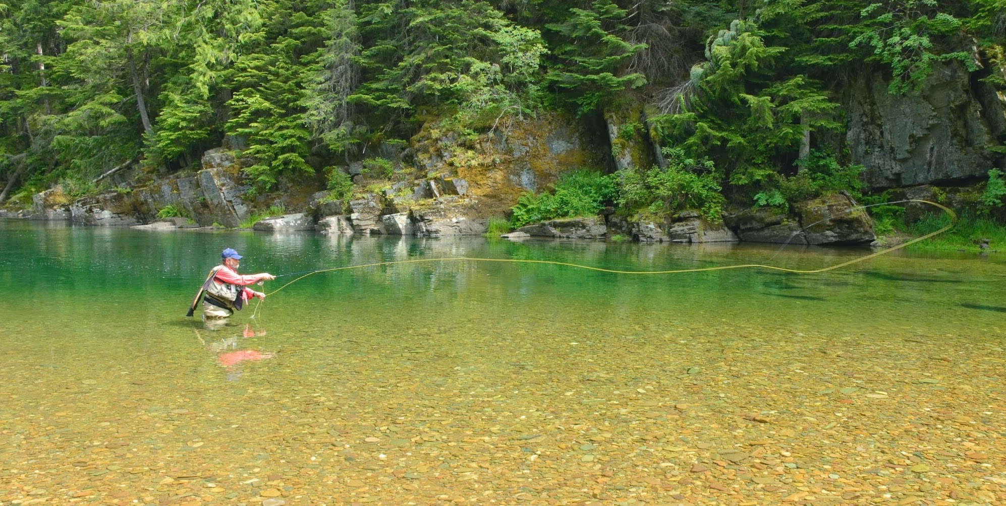 A man fly fishing on the St. Joe River in Northern Idaho