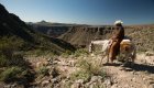 Horeseback rider with a white cowboy hat in the desert mountains of Baja, California