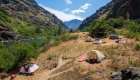 Riverside campsite with tents set up along the Salmon River in Idaho, offering a rejuvenating wellness retreat paired with whitewater rafting adventures.