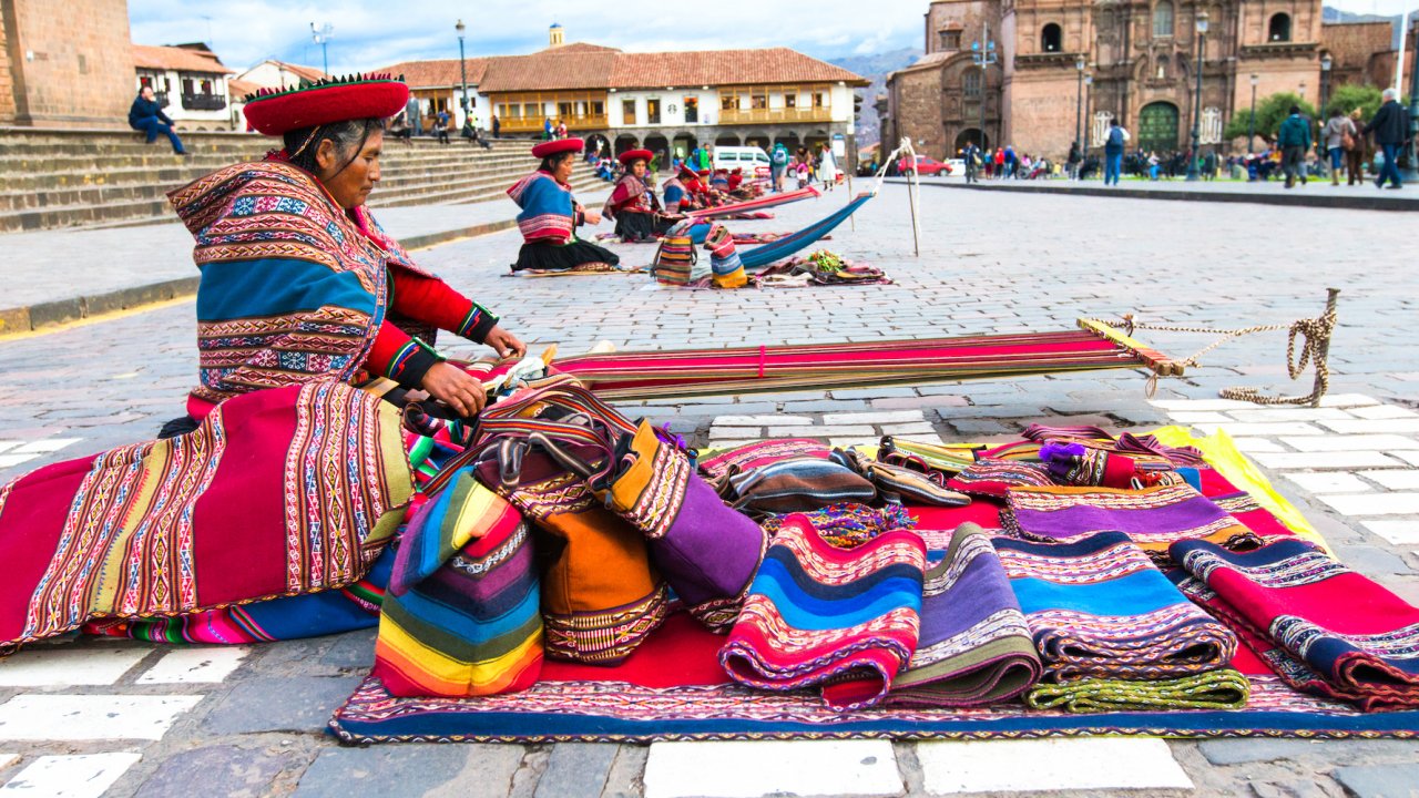 A Peruvian woman weaving traditional blankets in Lima