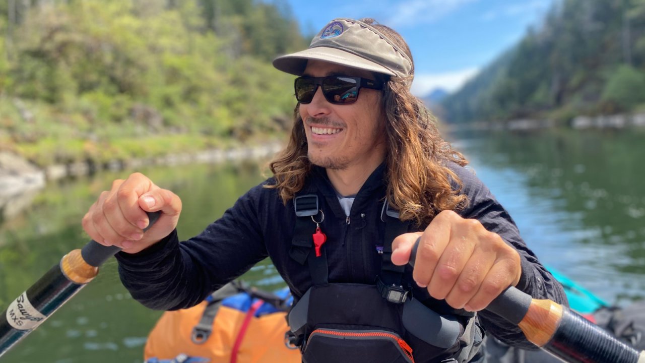 Meet Jake Baker, ROW Adventures Middle Fork Manager. male raft guide in boat with hands on oars
