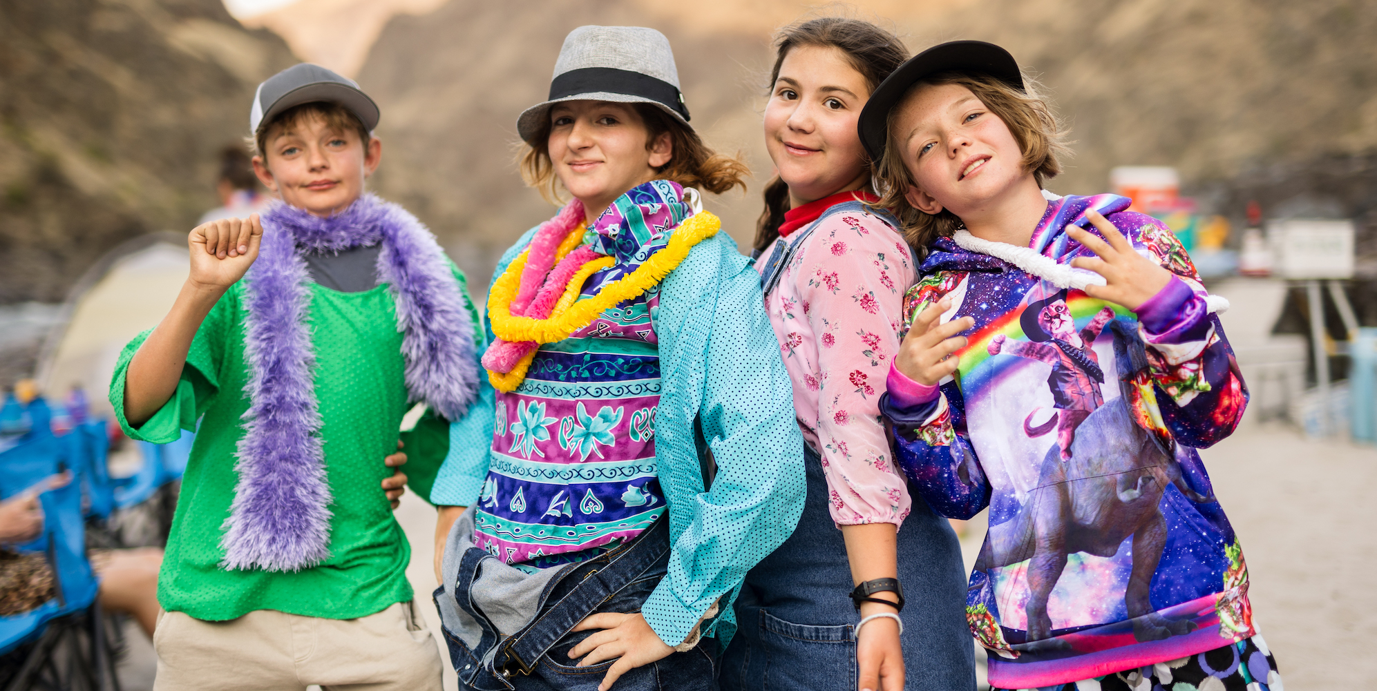 Four kids standing in a line in costumes smiling 