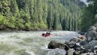 Lochsa River along with rocks on the shore while a raft in the distance moves downstream