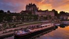 barge sitting in front of french city at sunset