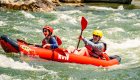 Guests enjoying a tandem inflatable kayak while rafting the Salmon River in Idaho.