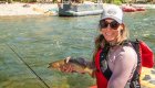 Woman holding a fish while on a rafting and fly fishing trip on the Middle Fork Salmon River