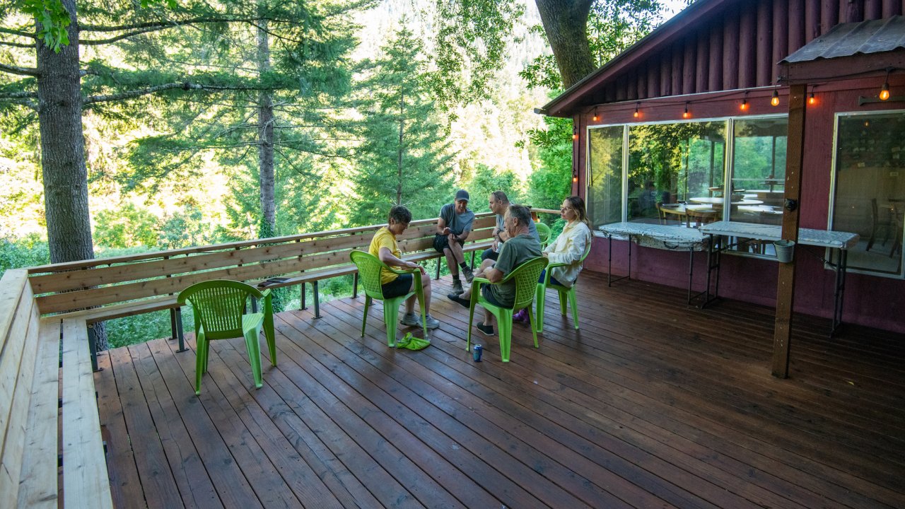 People relaxing on a wide open desk amongst the trees in the Rogue River Wilderness