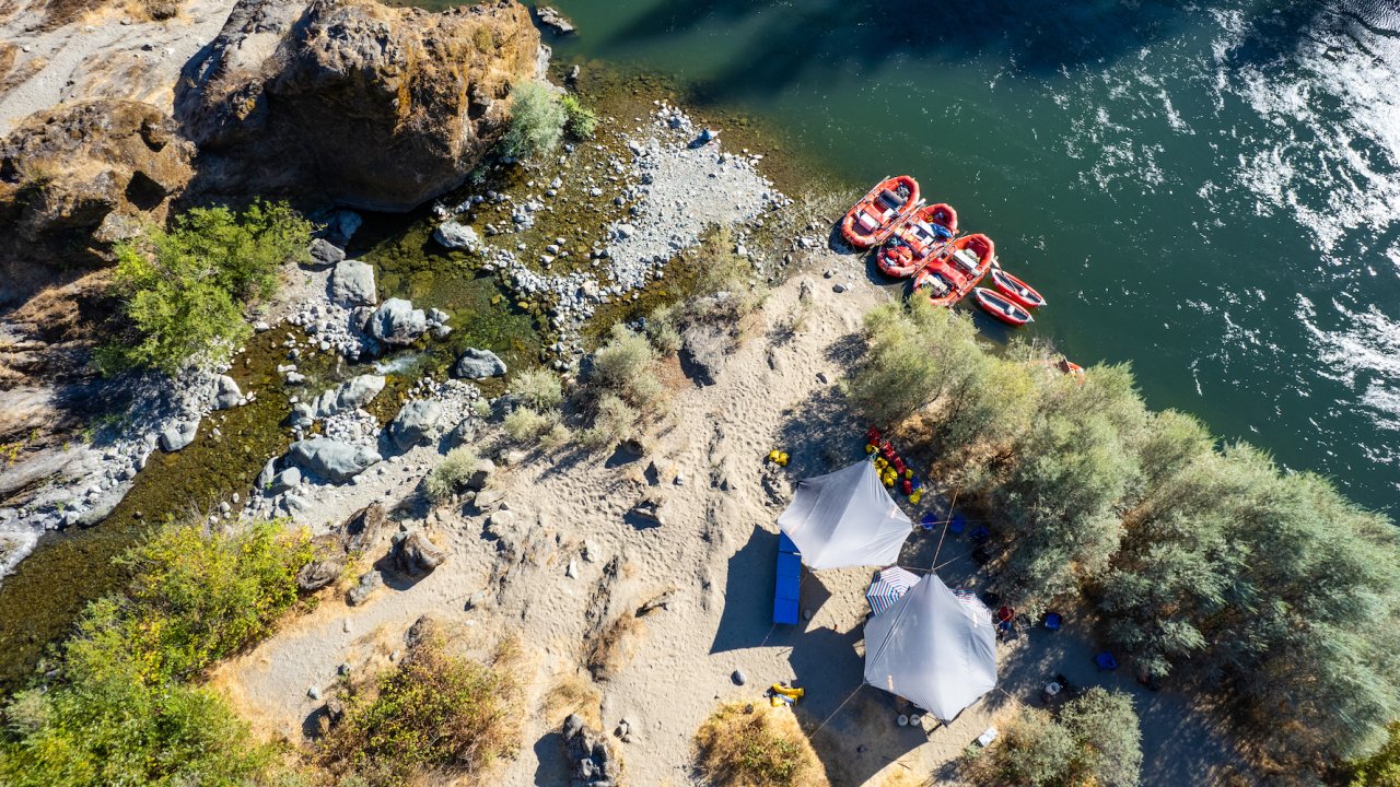Birds eye view of a camping set up on a sandy beach along the Rogue River