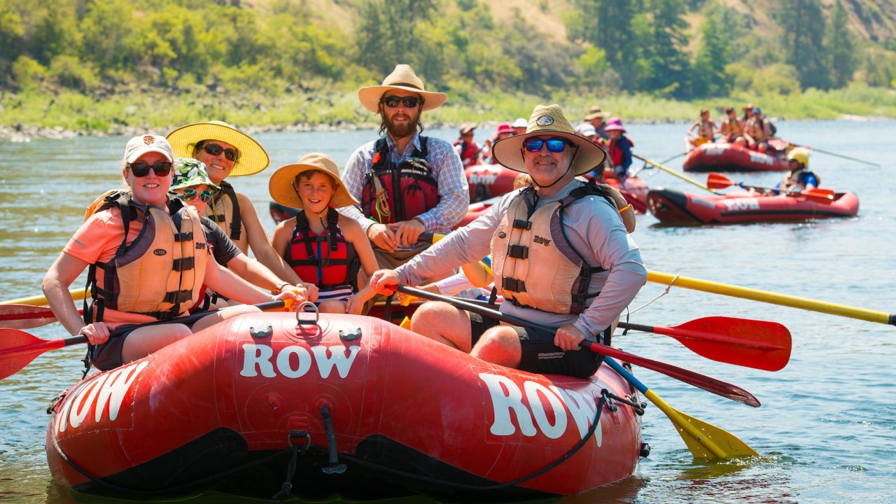 Rafting vacations for families enjoying a calm stretch of river on a guided family rafting trip with matching life vests