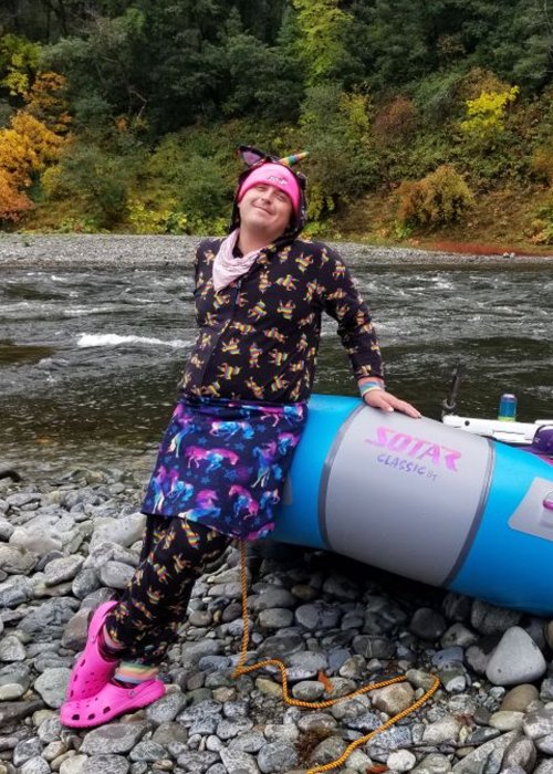 Oregon river guide leaning on blue and grey raft