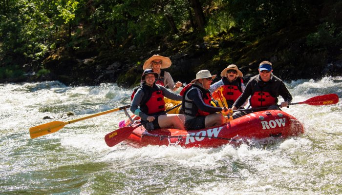red raft with 5 people on the rogue river in Oregon