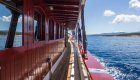 A view along the side deck of a wooden sailing yacht as it's moving through the Adriatic Sea.