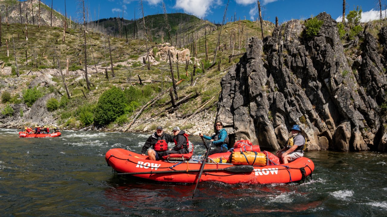 ROW guests pass by pervious fire damage on their rafting trip. red river raft with people