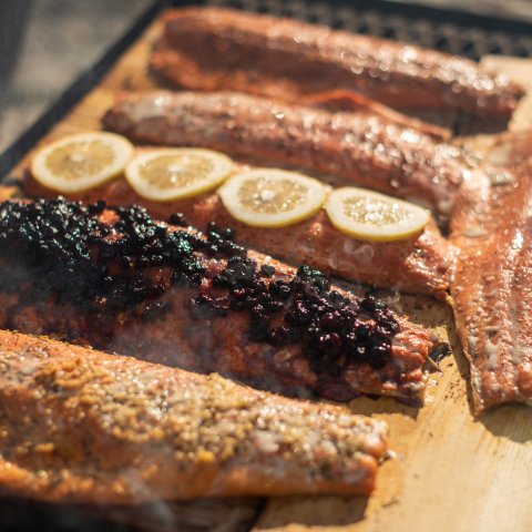 Filets of salmon on cedar blanks with lemon, huckleberries, and seasoning