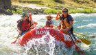 A red raft floating downstream through a splashy rapid on the Salmon rier