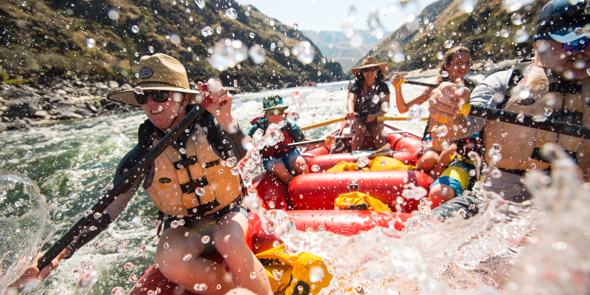 Group of rafting guests being splashed while rafting through a rapid on the Salmon River Canyons in Idaho.