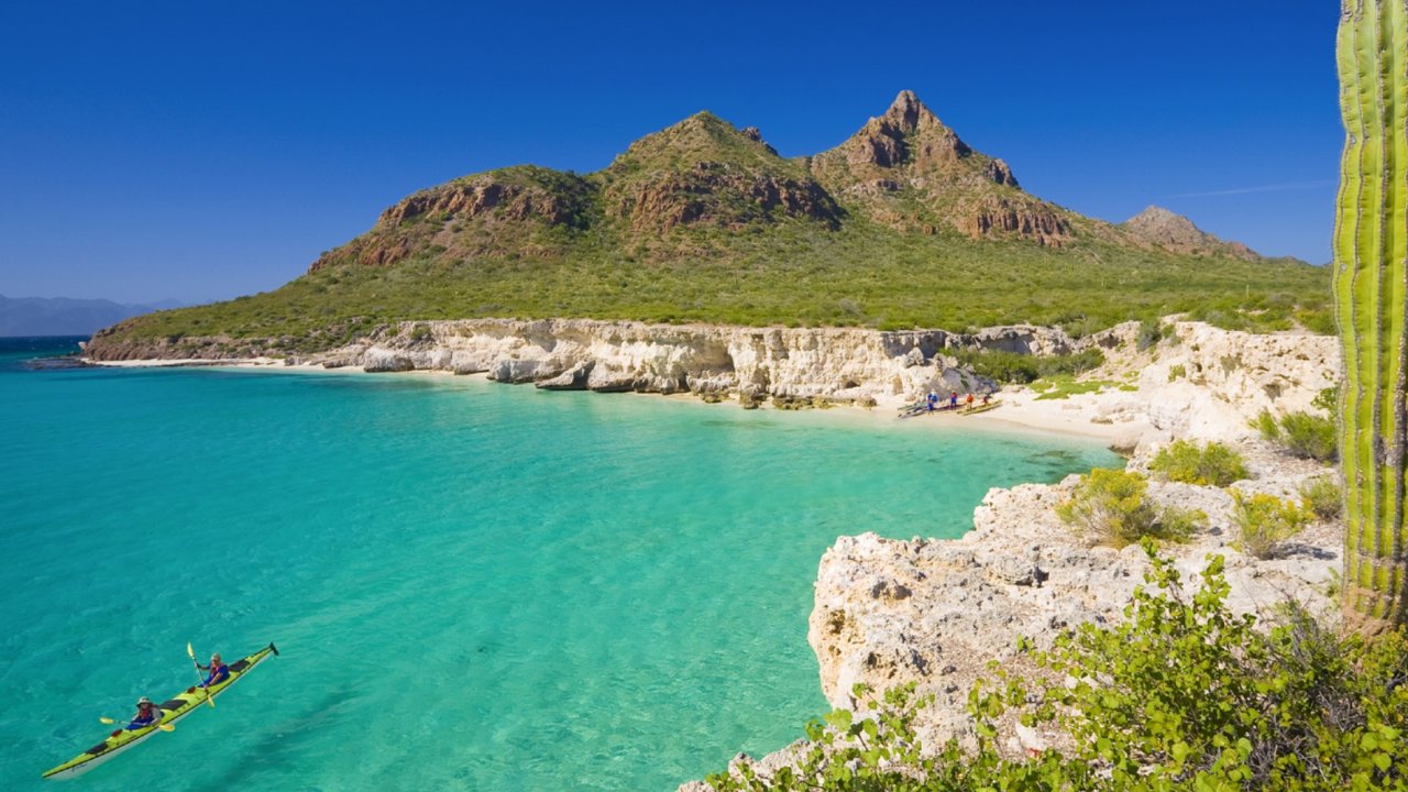 Kayaking through a scenic cove over turquoise water in Baja, Mexico