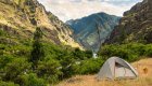 Camping tent along the Snake River in Hells Canyon, Idaho, with dramatic canyon walls and river views on a multi-day hiking and rafting tour.