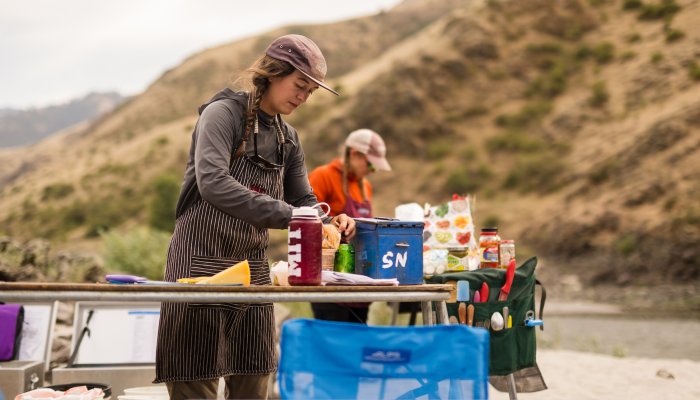 A multi-day river guide prepares dinner