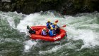 Birds eye view of a red raft with a guide and passengers rafting through the St. Joe river