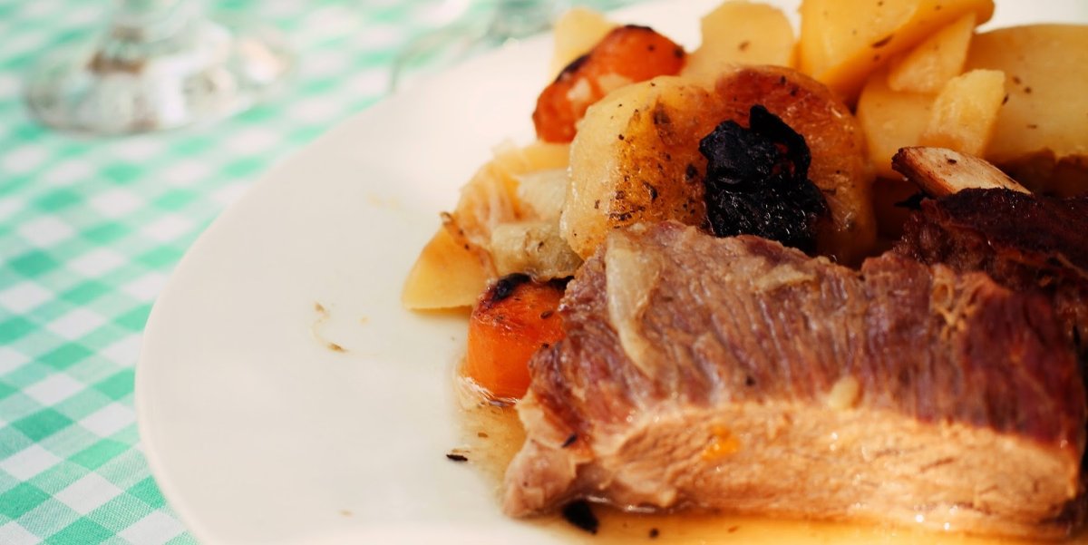 Steak with potatoes and carrots on a white plate 