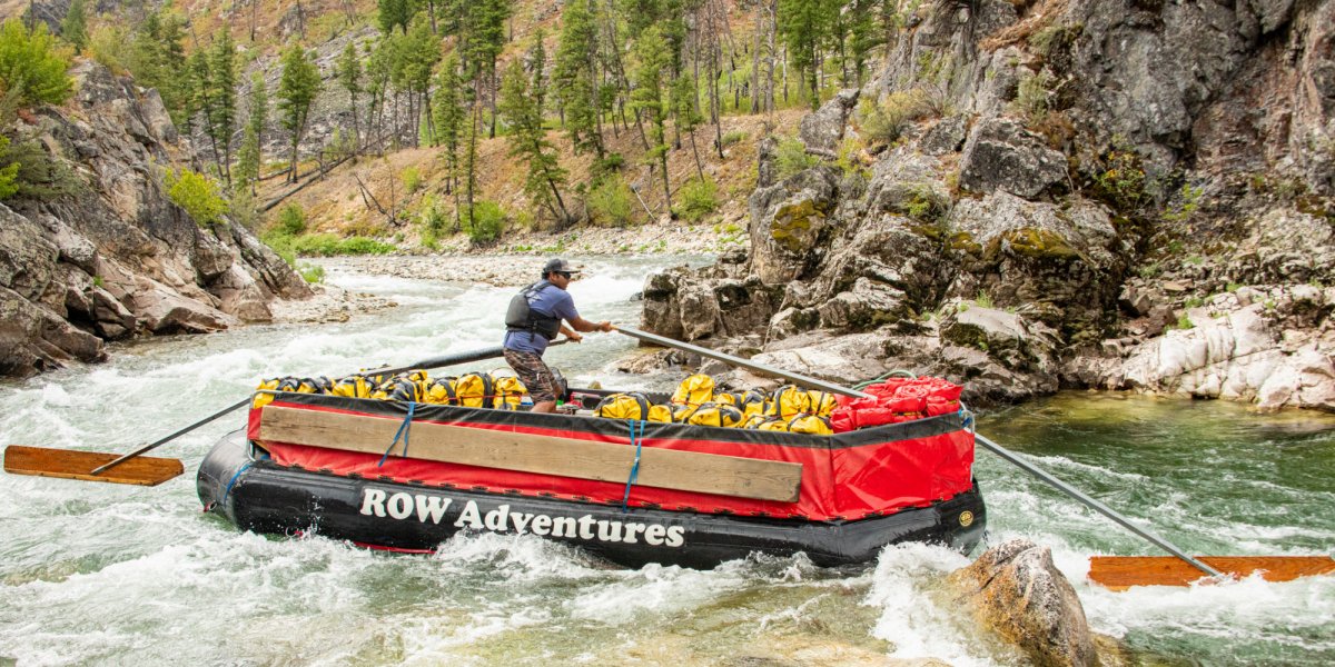 man navigates a raft in the river