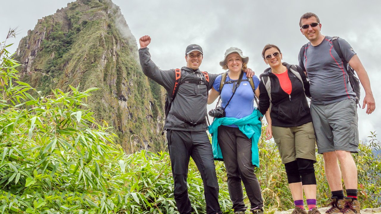Four hikers smiling while hiking the Inca Trail in Peru