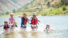 A group of kids on a family friendly rafting tour in Idaho playing on the Salmon river.