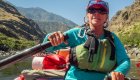 female guide rowing an oar raft