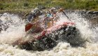 A red ROW Adventures raft crashing through a wave on the Owyhee river in Oregon during a guided rafting tour.