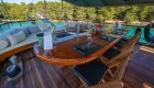 An outdoor dining area on a yacht in Croatia with a table set for a meal.