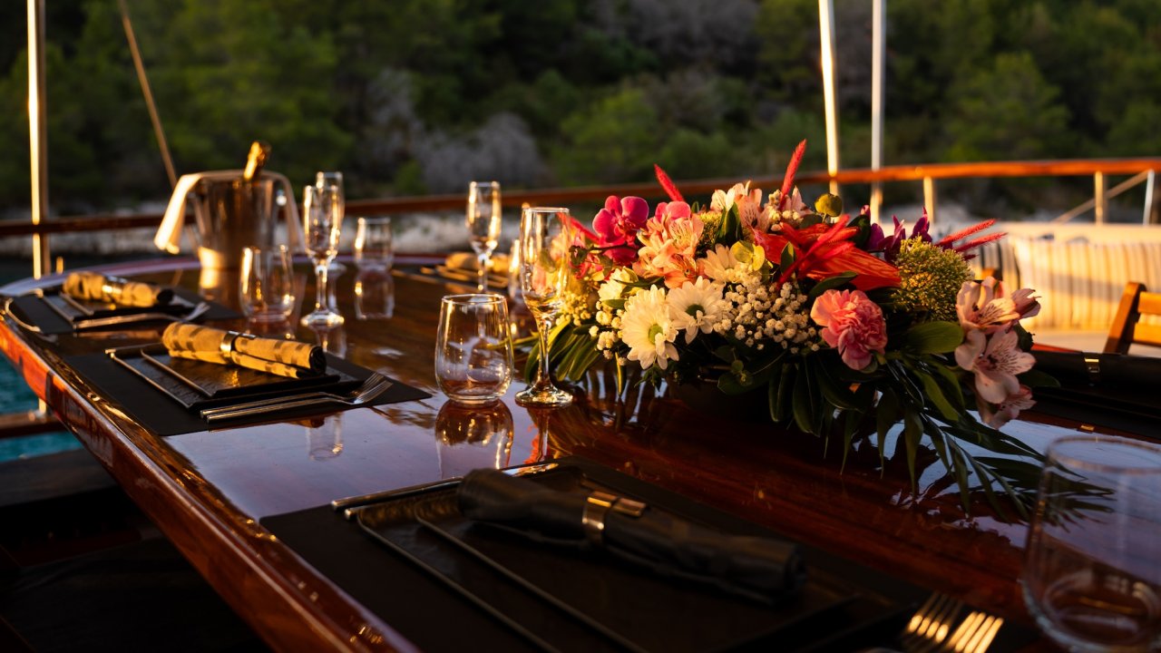 A set dining table on a Croatian yacht during sunset.